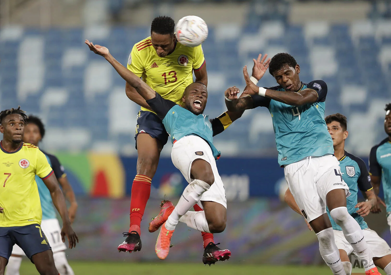 Colombia's Yerry Mina, top, Ecuador's Enner Valencia, center, and Ecuador's Robert Arboleda head for the ball during a Copa America soccer match at Arena Pantanal stadium in Cuiaba, Brazil, Sunday, June 13, 2021. (AP Photo/Andre Penner)