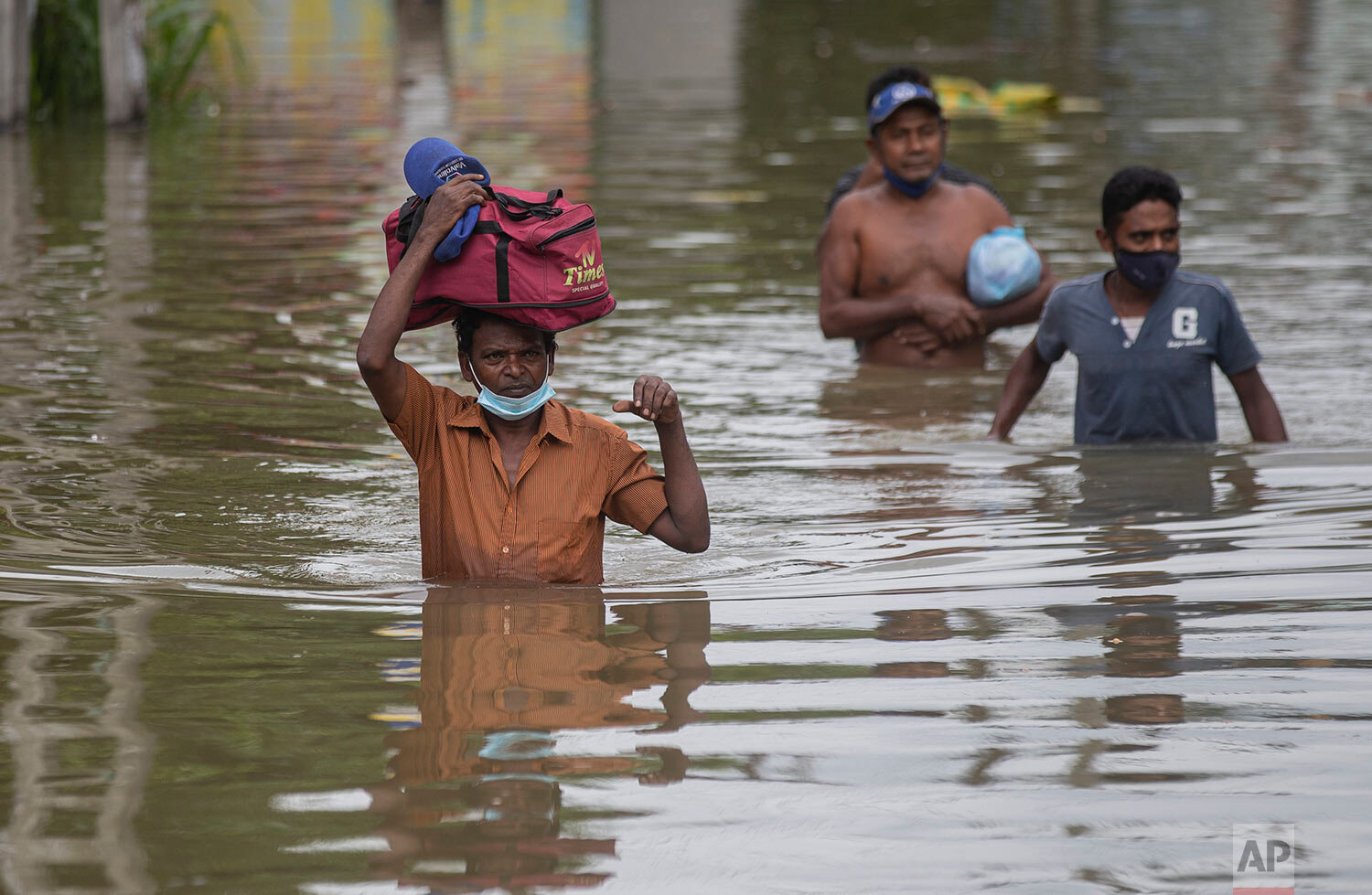  Sri Lankans wade through floodwaters following heavy rainfall at Malwana, on the outskirts of Colombo, Sri Lanka, Saturday, June 5, 2021.  (AP Photo/Eranga Jayawardena) 
