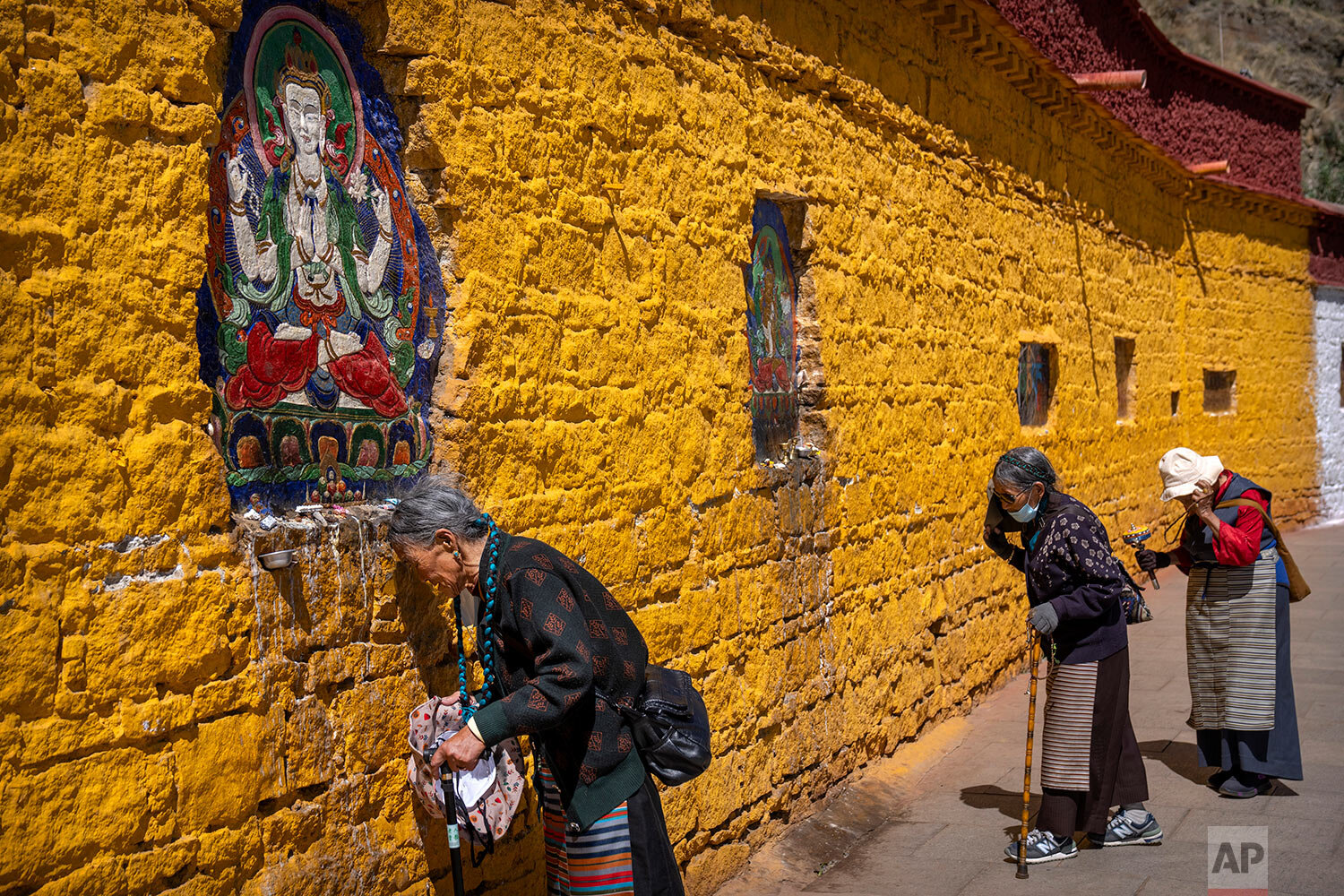  Members of the Buddhist faithful pray outside the Potala Palace in Lhasa in western China's Tibet Autonomous Region, as seen during a government organized visit for foreign journalists, Tuesday, June 1, 2021. (AP Photo/Mark Schiefelbein) 