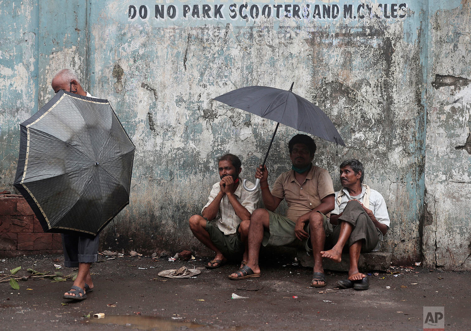  Daily wage laborers wait to be employed for the day, on a street in Mumbai, India, Friday, June 11, 2021. (AP Photo/Rafiq Maqbool) 
