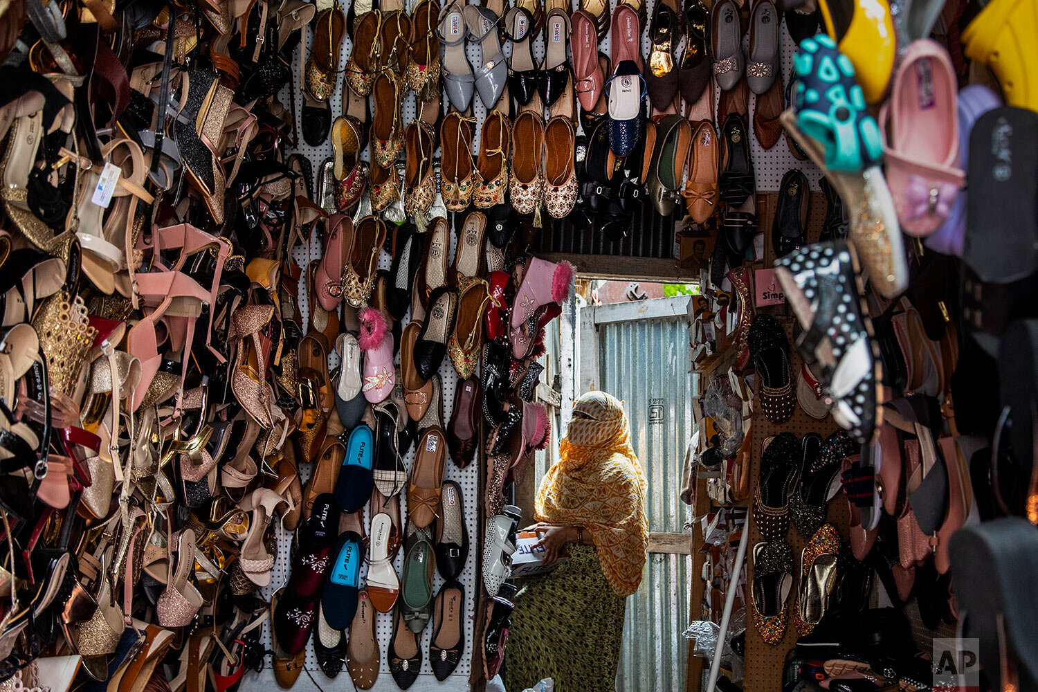  A shopkeeper arranges shoes during a partial relaxation of restrictions to curb the spread of coronavirus in Gauhati, India, Wednesday, June 9, 2021. (AP Photo/Anupam Nath) 