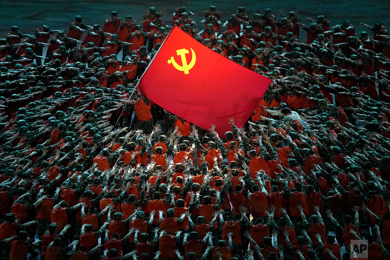  Performers dressed as rescue workers gather around the Communist Party flag during a gala show ahead of the 100th anniversary of the founding of the Chinese Communist Party in Beijing on Monday, June 28, 2021. (AP Photo/Ng Han Guan) 