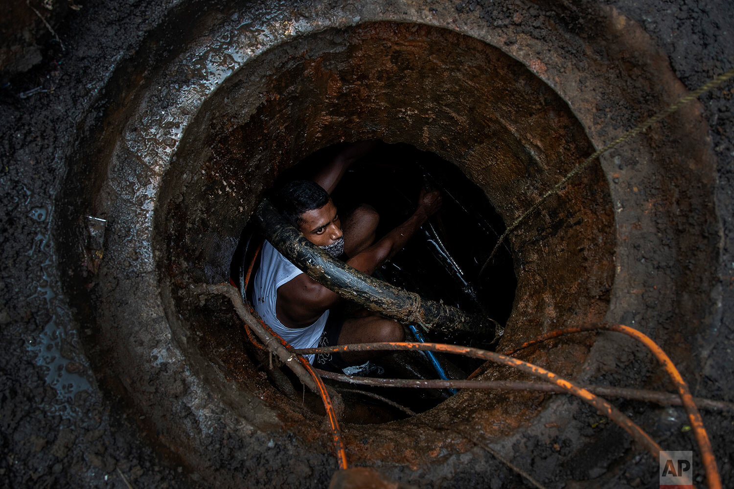  A telephone department worker repairs underground cables during a partial relaxation of restrictions to curb the spread of coronavirus in Gauhati, India, Wednesday, June 9, 2021. (AP Photo/Anupam Nath) 