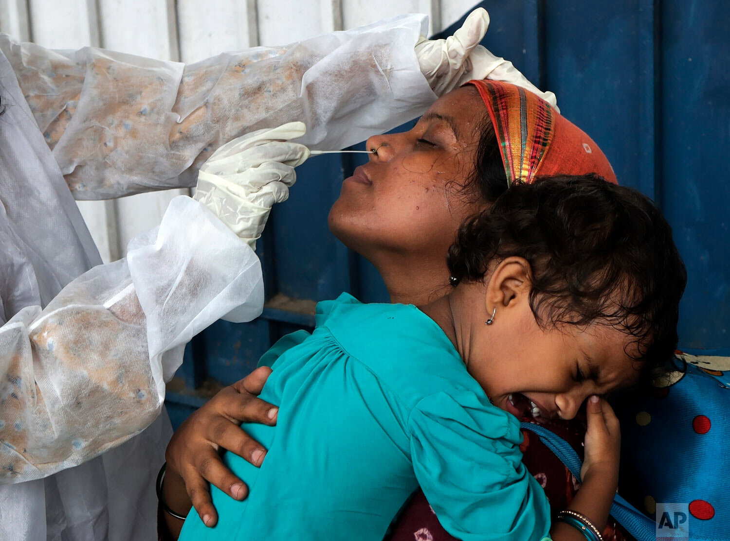  A health worker collects swab sample of traveler to test for COVID-19 at a train station in Mumbai, India, Thursday, June 17, 2021. (AP Photo/Rajanish Kakade) 