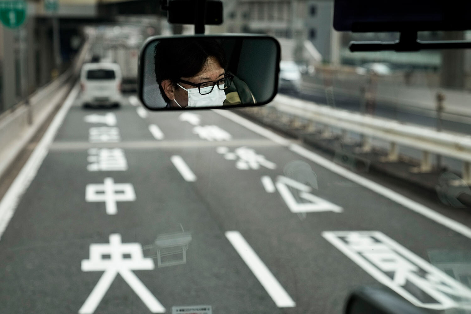  A bus driver is reflected in the mirror, Tuesday, July 13, 2021, in Tokyo. (AP Photo/Jae C. Hong) 
