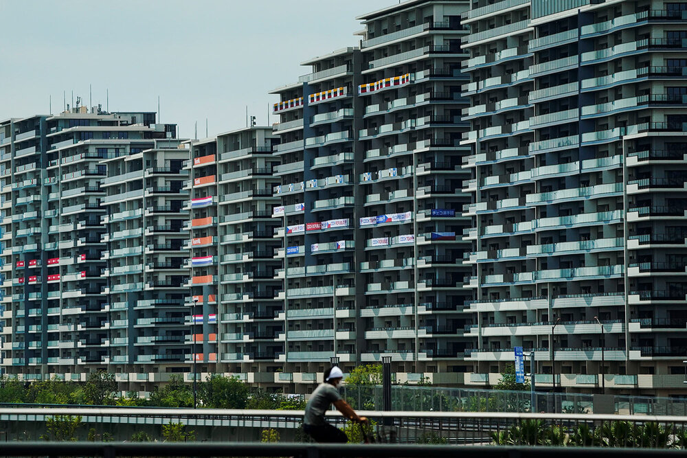  A man rides his bike near the athlete's village for the 2020 Summer Olympics and Paralympics, Thursday, July 15, 2021, in Tokyo. (AP Photo/Jae C. Hong) 