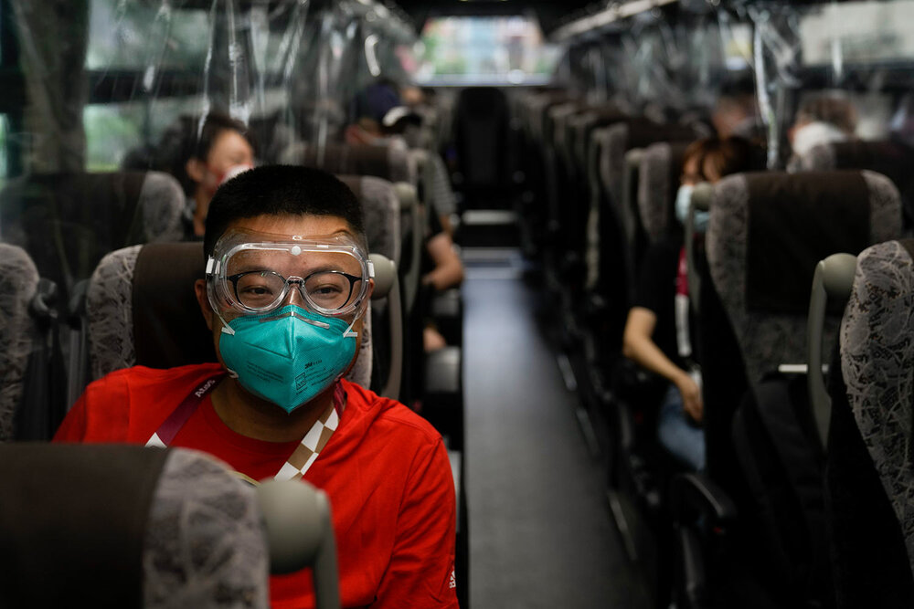  Hua Zhang, of the China Media Group, wears protective goggles while riding a media bus ahead the 2020 Summer Olympics, Wednesday, July 14, 2021, in Tokyo. (AP Photo/Jae C. Hong) 