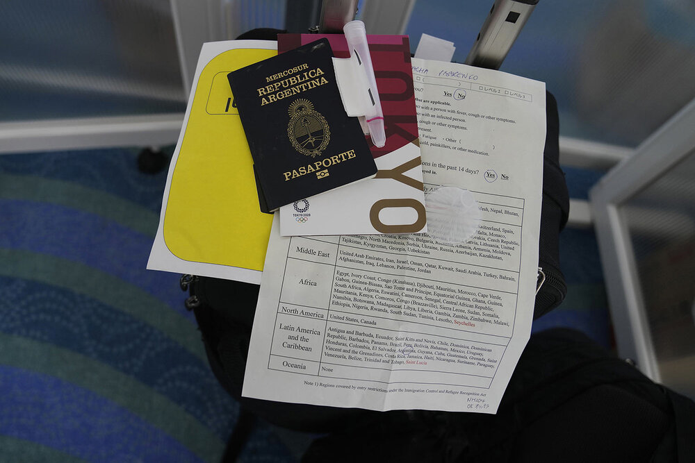  Associated Press photographer’s Natacha Pisarenko documents rest on her suitcase at Haneda Airport in Tokyo upon arriving Monday, July 19, 2021. (AP Photo/Natacha Pisarenko) 