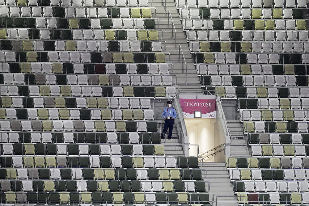  A security officer looks out over an empty stadium before the opening ceremony in the Olympic Stadium at the 2020 Summer Olympics, Friday, July 23, 2021, in Tokyo, Japan. (AP Photo/David J. Phillip) 