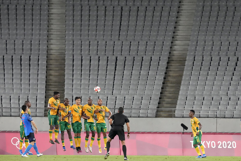  Japan's Maya Yoshida, left, takes a penalty kick against South Africa as the stands sit empty during a men's soccer match at the 2020 Summer Olympics, Thursday, July 22, 2021, in Tokyo, Japan. Disputed, locked down and running a year late, the Tokyo