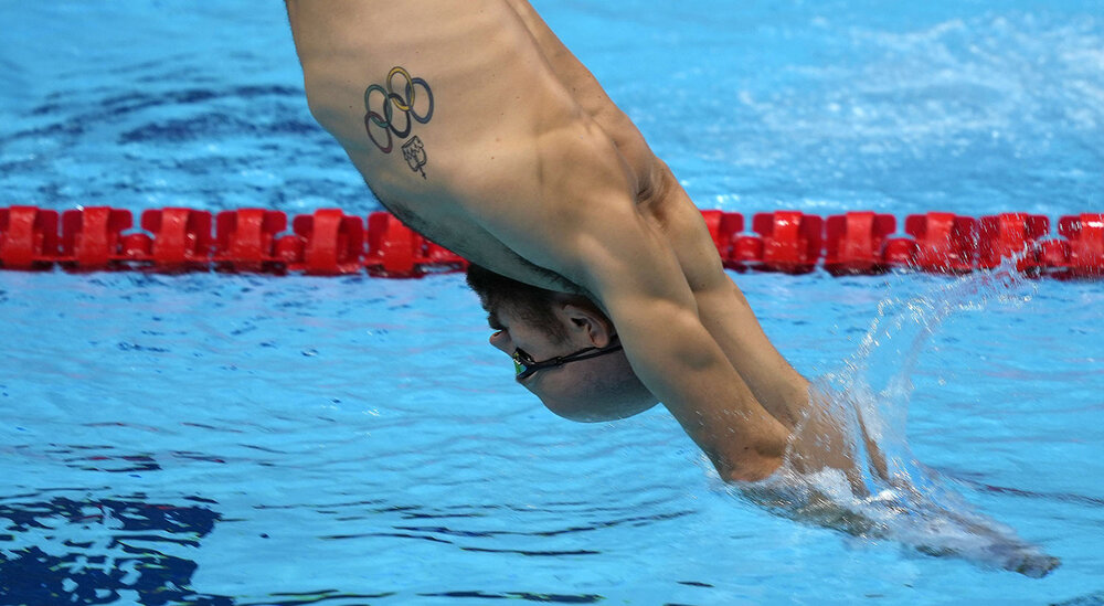  A swimmer with an Olympic tattoo exercises during a swimming training session at the Tokyo Aquatics Centre at the 2020 Summer Olympics, Wednesday, July 21, 2021, in Tokyo, Japan. (AP Photo/Martin Meissner) 