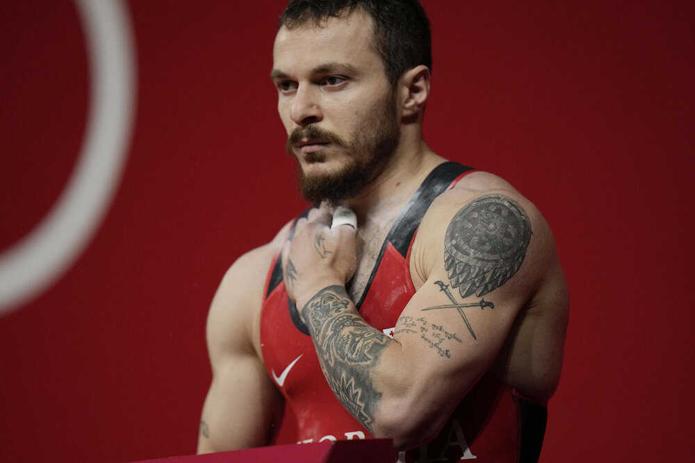  Shota Mishvelidze of Georgia prepares to compete in the men's 61kg weightlifting event, at the 2020 Summer Olympics, Sunday, July 25, 2021, in Tokyo, Japan. (AP Photo/Luca Bruno) 