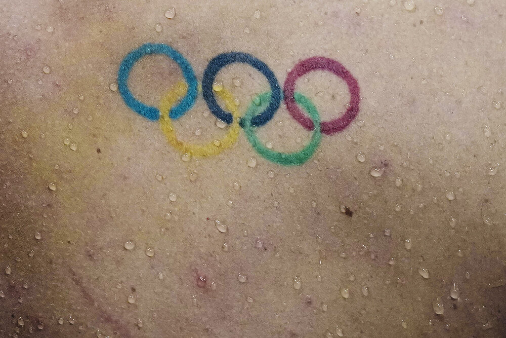  Water droplets fall down the back over a Olympics rings tattoo of Townley Haas, of the United States, swims at the 2020 Summer Olympics, Sunday, July 25, 2021, in Tokyo, Japan. (AP Photo/Charlie Riedel) 