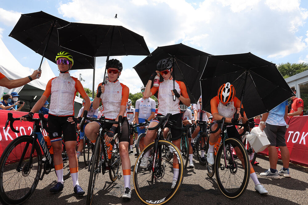  Annemiek van Vleuten, from left, Anna van der Breggen, Demi Vollering and Marianne Vos of the Netherlands protect from the sun with an umbrella before they compete in the women's cycling road race at the 2020 Summer Olympics, Sunday, July 25, 2021, 