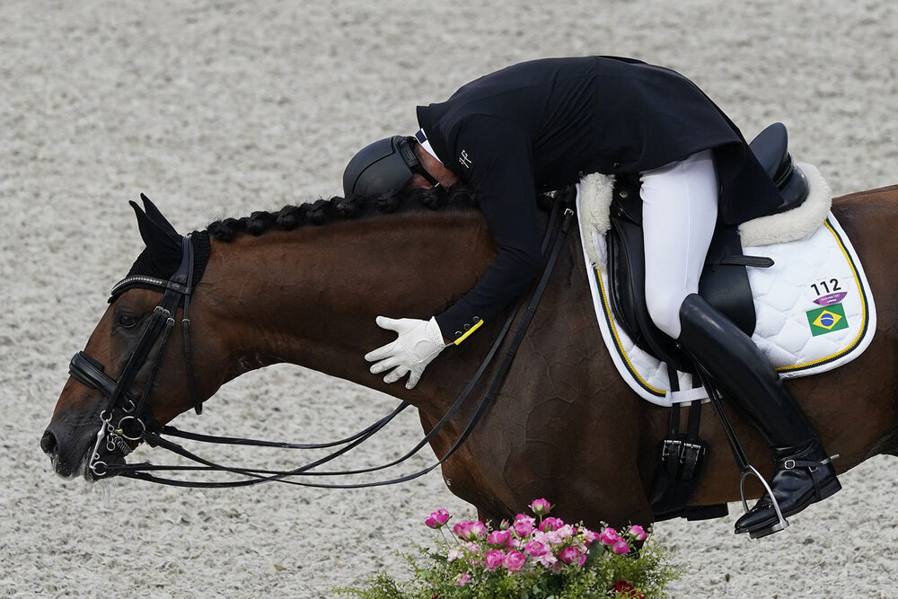  Brazil's Joao Victor Marcari Oliva, hugs Escorial Horsecampline as he celebrates after competing during the dressage Grand Prix competition at Equestrian Park the 2020 Summer Olympics, Saturday, July 24, 2021, in Tokyo, Japan. (AP Photo/Carolyn Kast