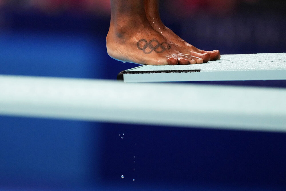  A tattoo of the Olympic rings decorate the foot of Jennifer Abel, of Canada, as she prepares to dive in the women's diving 3-meter springboard preliminary at the 2020 Summer Olympics, Friday, July 30, 2021, in Tokyo. (AP Photo/David Goldman) 