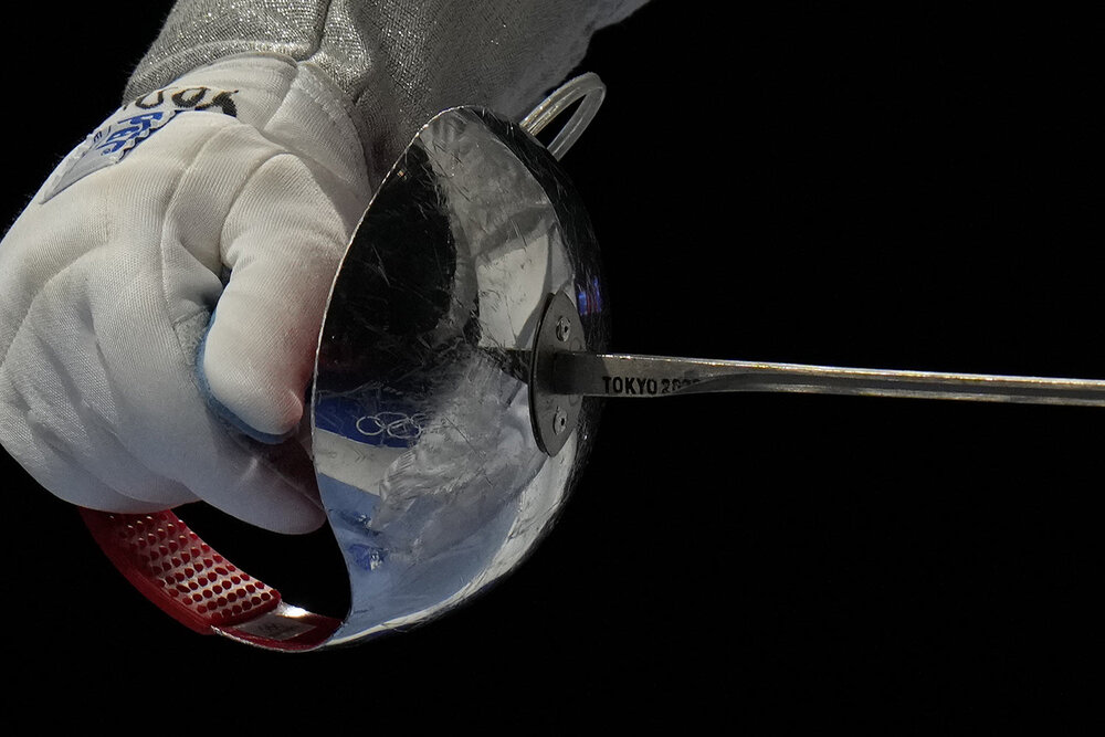  The Olympic rings are reflected in the men's individual Sabre team round of 16 between Japan and Egypt competition at the 2020 Summer Olympics, Tuesday, July 27, 2021, in Chiba, Japan. (AP Photo/Hassan Ammar) 