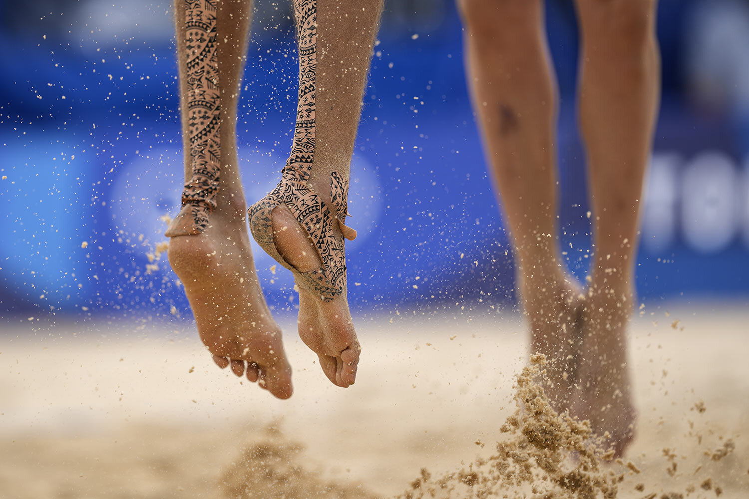  Konstantin Semenov, left, of the Russian Olympic Committee, with tape on his feet jumps during a men's beach volleyball match against Australia at the 2020 Summer Olympics, Monday, July 26, 2021, in Tokyo, Japan. (AP Photo/Petros Giannakouris) 