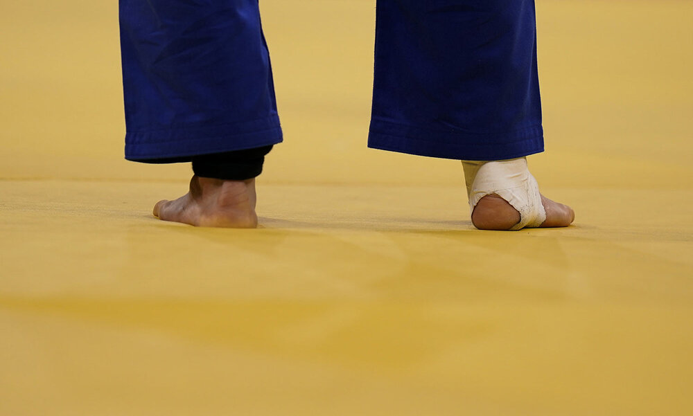  Kim Won-jin, of South Korea, stands on the mat with his ankle taped around while competing against Yeldos Smetov, of Kazakhstan, during their mens -60kg quarterfinals judo match at the 2020 Summer Olympics, Saturday, July 24, 2021, in Tokyo, Japan. 