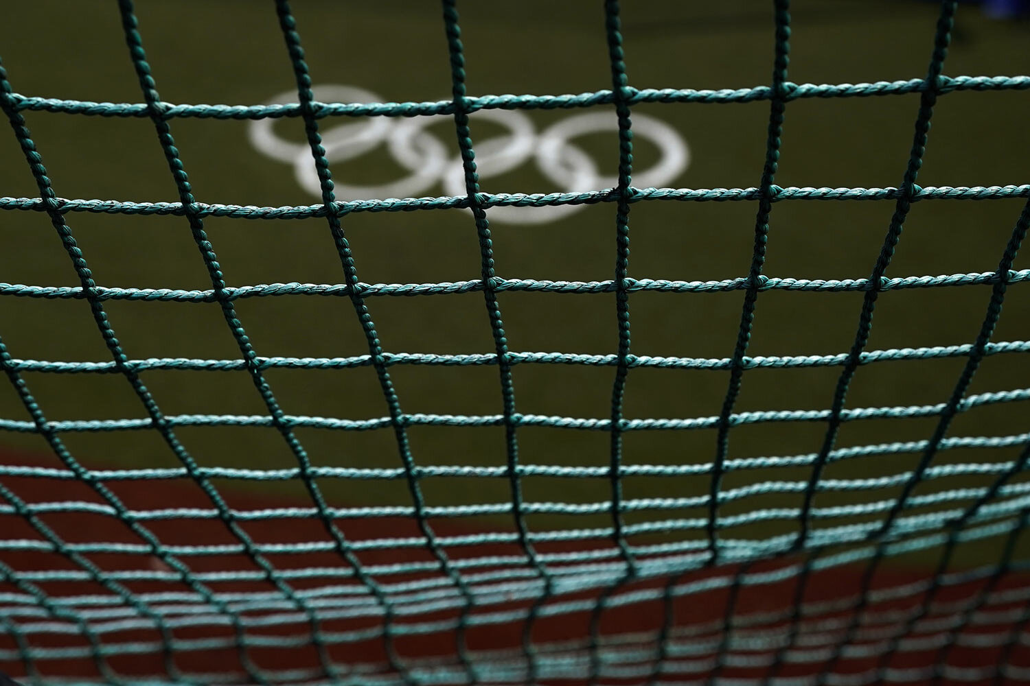  The Olympic rings painted on the field are seen through a net as U.S. softball players take batting practice at the Fukushima Azuma Baseball Stadium ahead of the 2020 Summer Olympics, Tuesday, July 20, 2021, in Fukushima, Japan. (AP Photo/Jae C. Hon