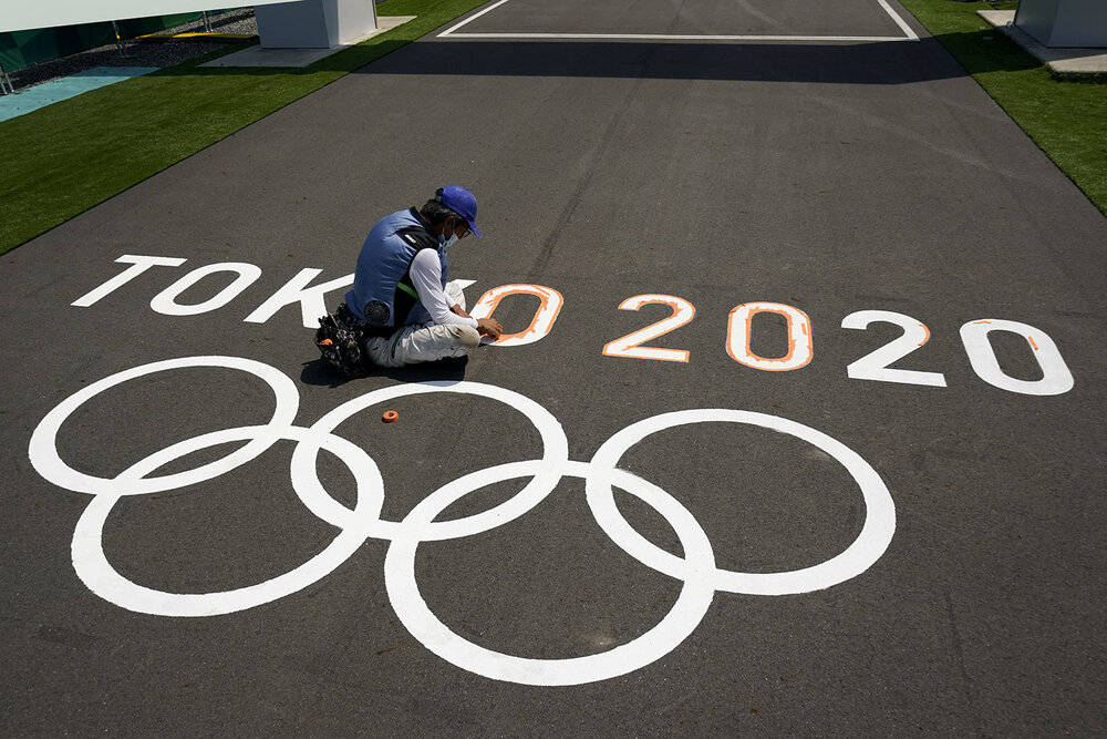  A worker paints Olympic rings at the finish line of the BMX racing track as preparations continue for the 2020 Summer Olympics, Tuesday, July 20, 2021, at the Ariake Urban Sports Park in Tokyo. (AP Photo/Charlie Riedel) 