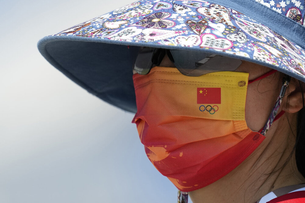  Chinese national flag and the Olympic rings are seen on the mask of a member of Chinese rowing team during a rowing training session at the 2020 Summer Olympics, Thursday, July 22, 2021, in Tokyo, Japan. (AP Photo/Lee Jin-man) 