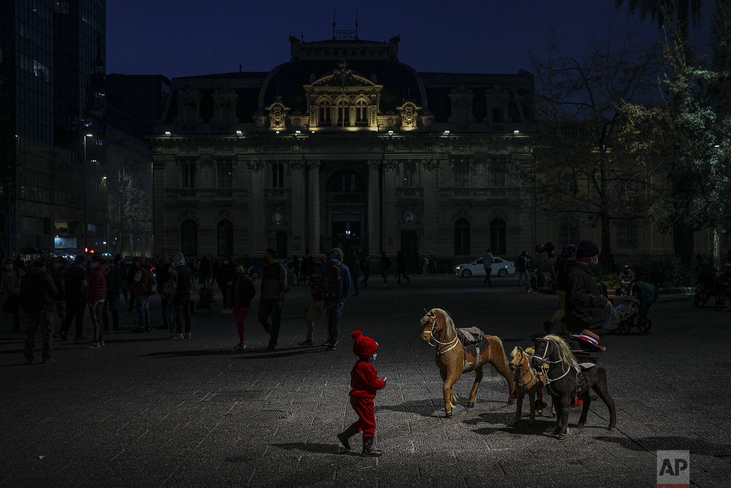  A girl walks near a street photographer’s wooden horses at the Plaza de Armas in downtown Santiago, Chile, Tuesday, July 20, 2021, amid the COVID-19 pandemic. The capital is moving into phase three, ending weekend quarantines and allowing more peopl