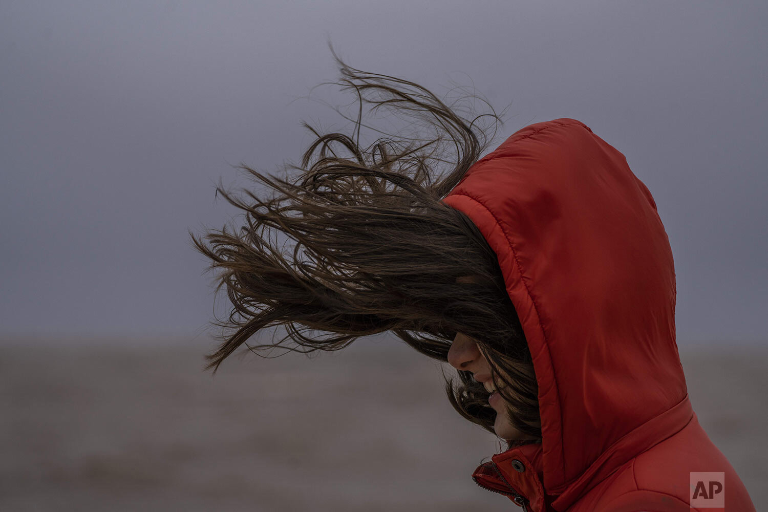  A person’s hair gets blown around as they walk on the sea wall in Montevideo, Uruguay,Sunday, July 18, 2021. (AP Photo/Matilde Campodonico) 