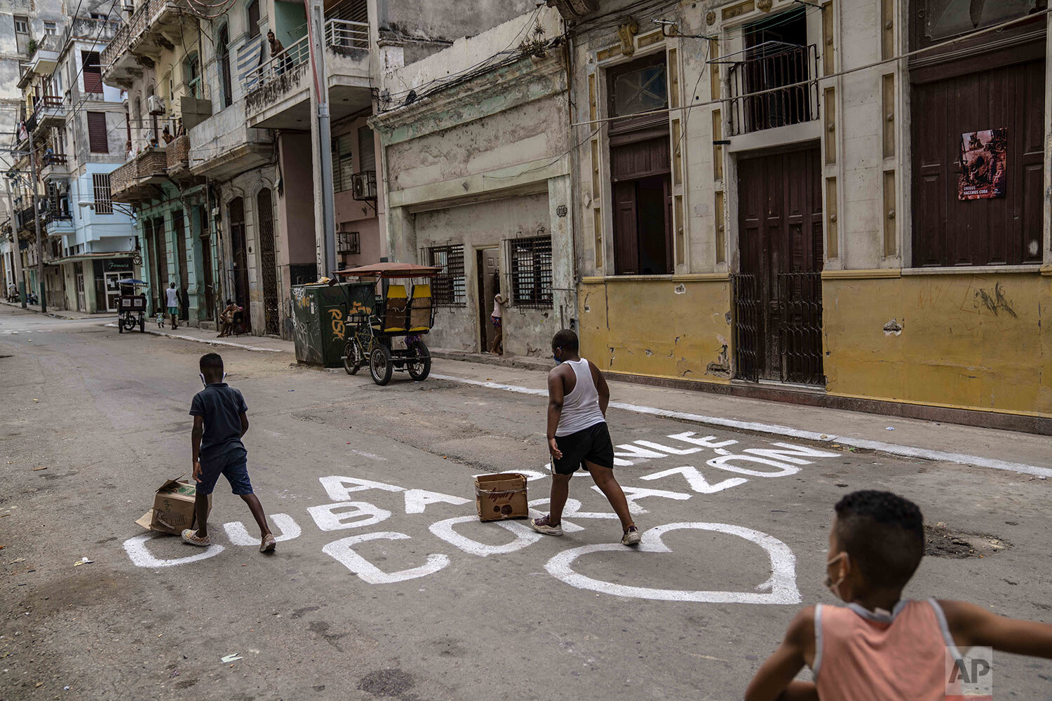  Children play on a street covered by the Spanish phrase “Put your heart into Cuba” in Havana, Cuba, Monday, July 26, 2021 (AP Photo/Eliana Aponte) 