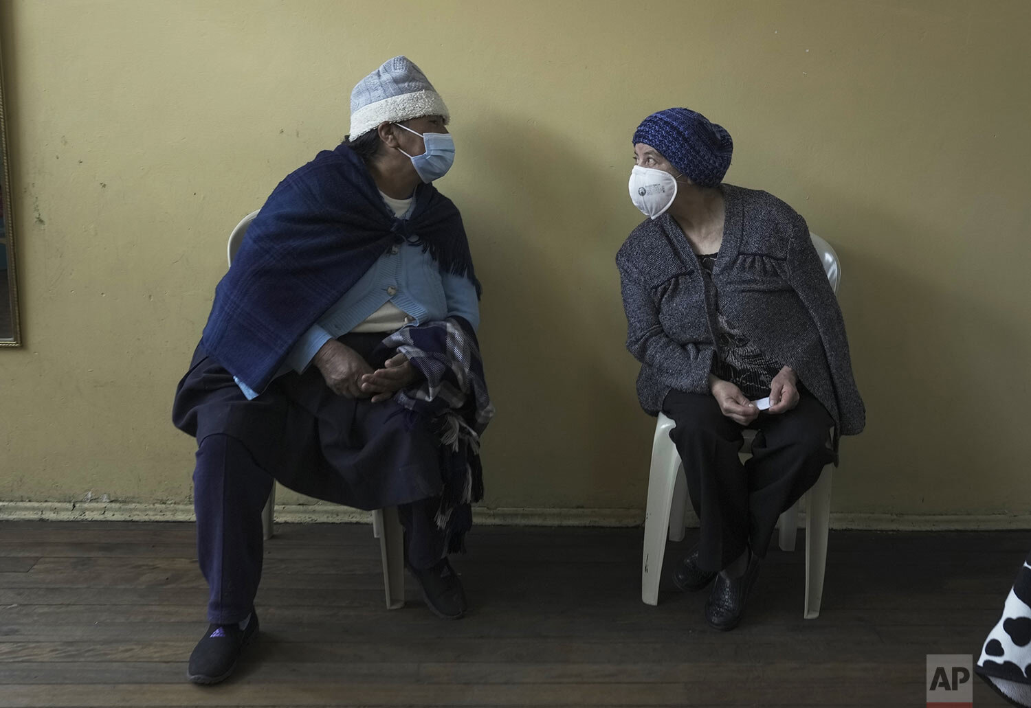  Women visit as they wait for a shot of the COVID-19 vaccine in Pillaro, Ecuador, Thursday, July 8, 2021. (AP Photo/Dolores Ochoa) 