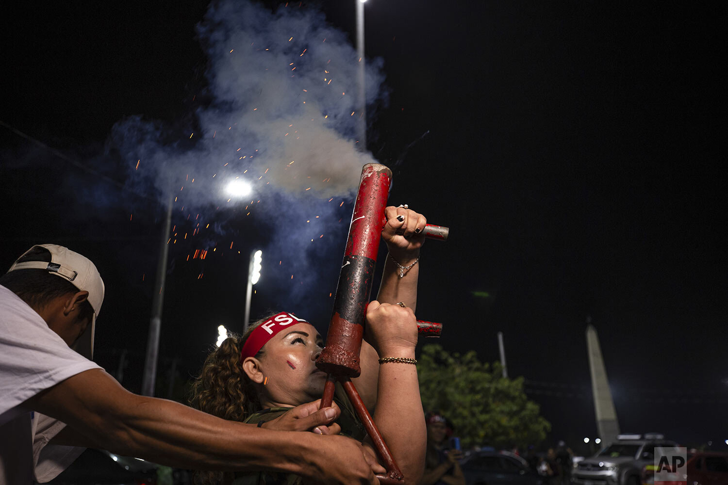  A woman fires a homemade mortar during commemorations for the 42nd anniversary of the triumph of the 1979 Sandinista Revolution that toppled dictator Anastasio Somoza in Managua, Nicaragua, late Sunday, July 18, 2021. (AP Photo/Miguel Andrés) 