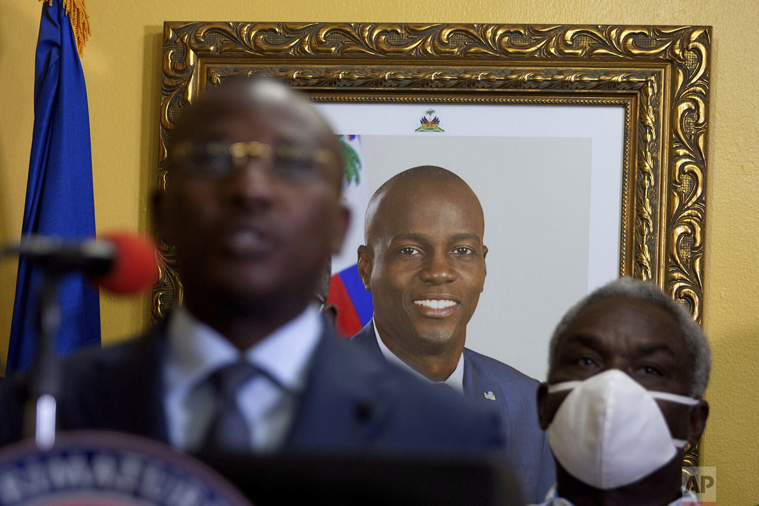  A picture of late Haitian President Jovenel Moise hangs on the wall of his former residence, behind interim Prime Minister Claude Joseph giving a press conference in Port-au-Prince, Tuesday, July 13, 2021. Authorities in Haiti forcefully pushed back