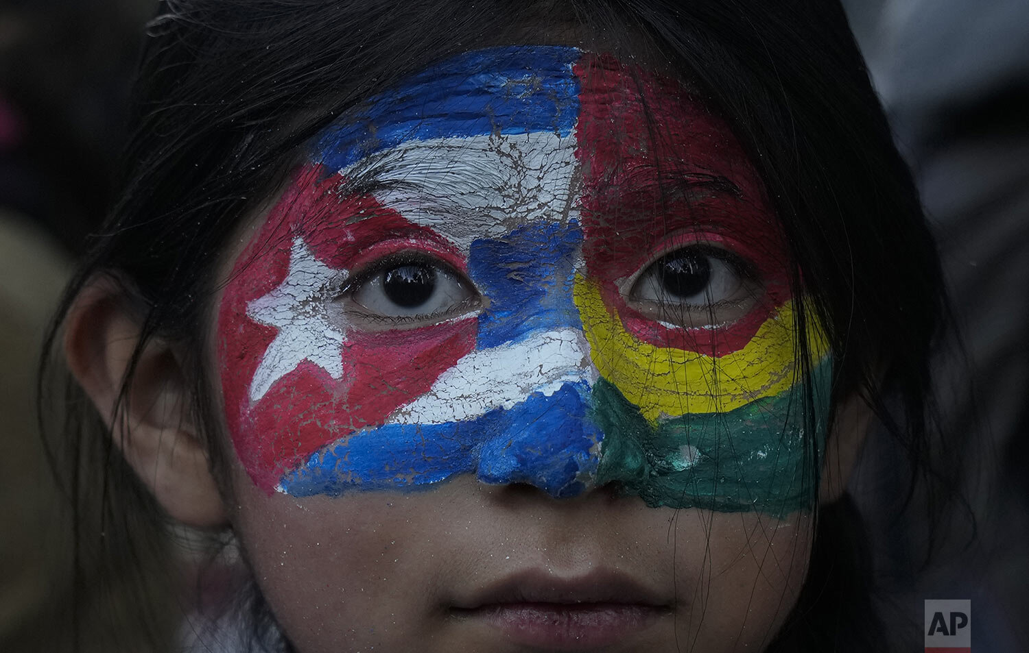  A girl with Cuban and Bolivian colors painted on her face takes part a march in support of the Cuban government, near the U.S. embassy in La Paz, Bolivia, Wednesday, July 14, 2021. The march came about after a rare weekend of protests against the co