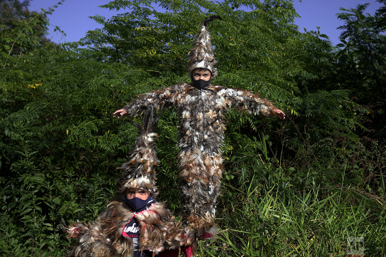  Brothers Lucas, 7,  left, and Josias, 9, pose for a portrait wearing their feathered costumes during the feast of St. Francis Solano in Emboscada, Paraguay, Saturday, July 24, 2021.  According their mother they are taking part in the festivities to 