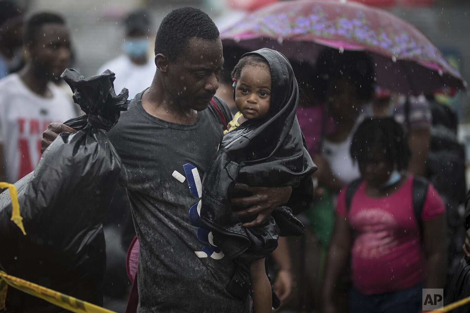 A Haitian migrant carries a baby to a boat that will take them to Capurgana, on the border with Panama, from Necocli, Colombia, early Thursday, July 29, 2021. Migrants have been gathering in Necocli as they move north towards Panama on their way to 