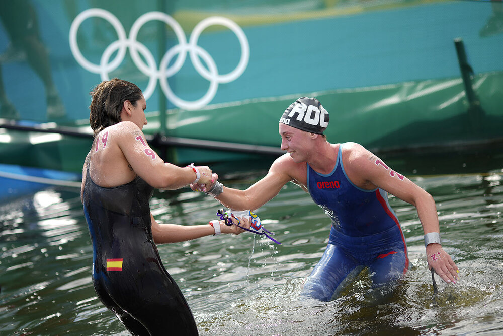  Paula Ruiz Bravo, of Spain, left, helps up Anastasiia Kirpichnikova, of the Russian Olympic Committee, after they finished in the women's marathon swimming event at the 2020 Summer Olympics, Wednesday, Aug. 4, 2021, in Tokyo. (AP Photo/David Goldman