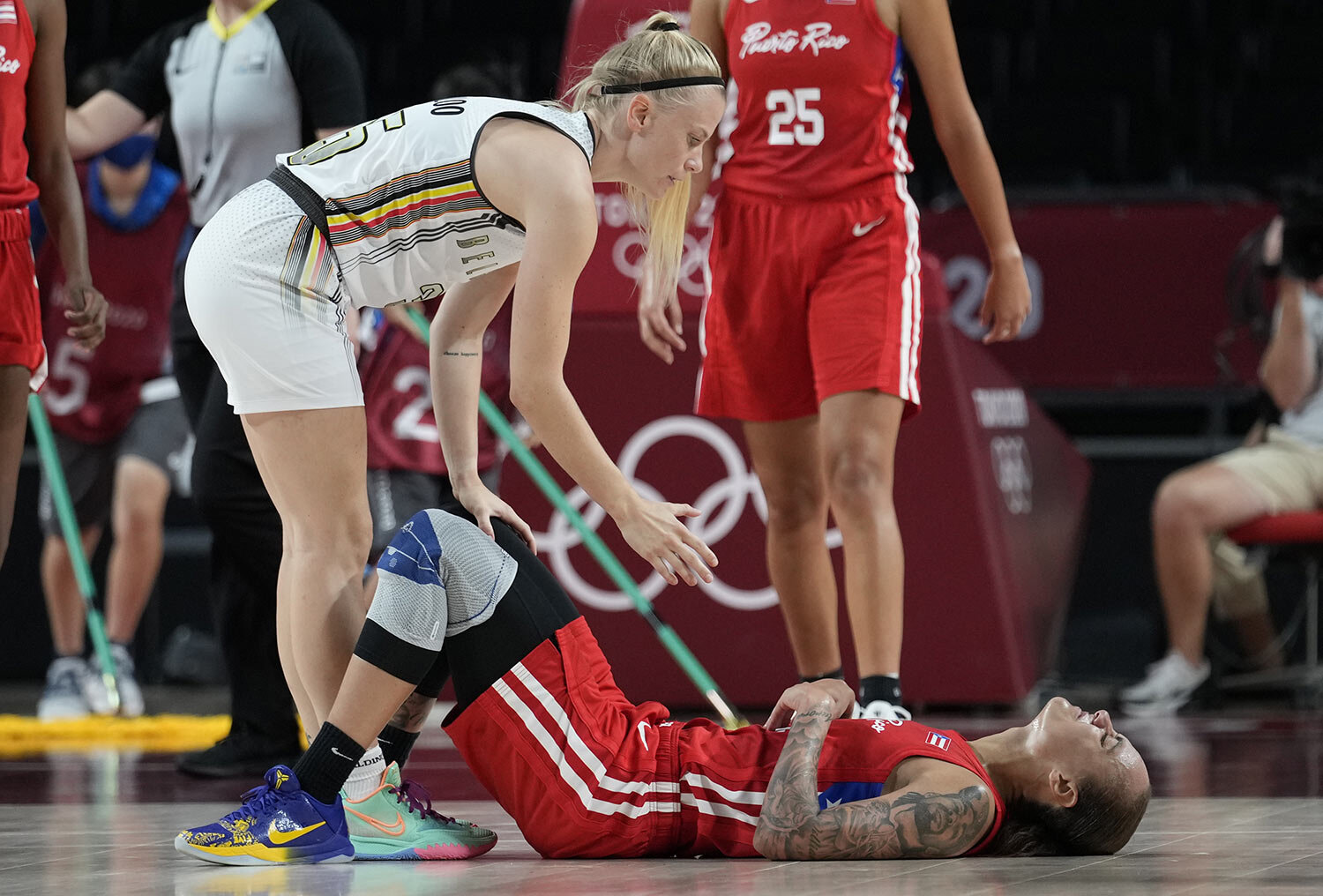  Belgium's Julie Vanloo (35), left, offers help to Puerto Rico's Jazmon Gwathmey (24) during women's basketball preliminary round game between Belgium and Puerto Rico at the 2020 Summer Olympics, Friday, July 30, 2021, in Saitama, Japan. (AP Photo/Er