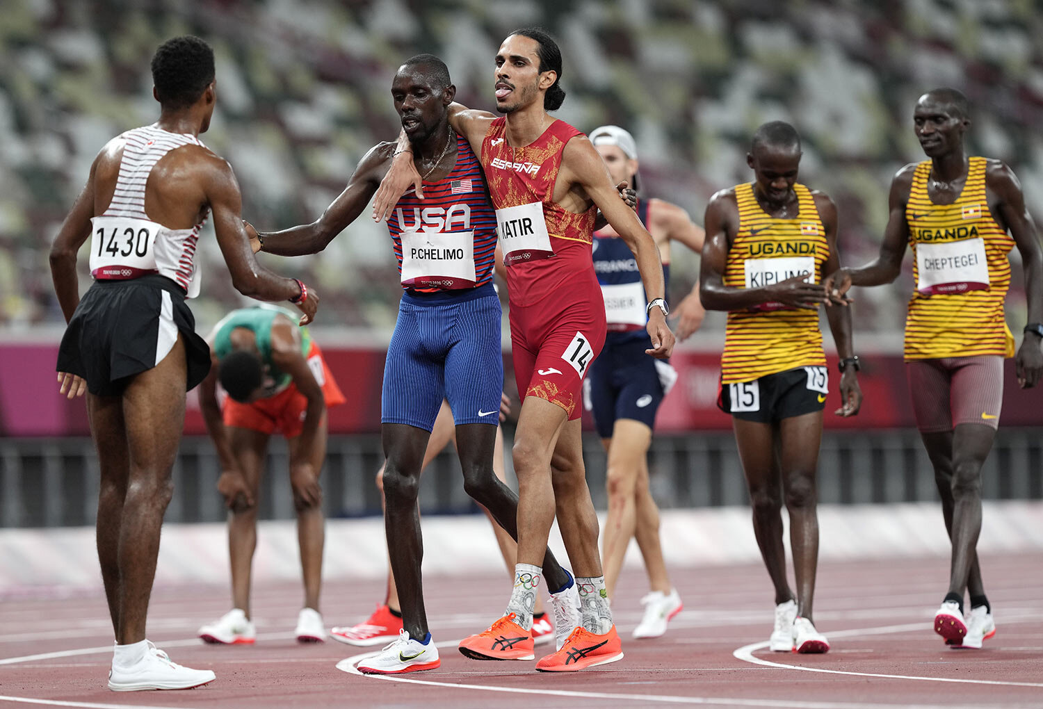  Mohamed Katir, of Spain and Paul Chelimo, of United States embrace as they finish in a men's 5,000-meter heat at the 2020 Summer Olympics, Tuesday, Aug. 3, 2021, in Tokyo, Japan. (AP Photo/Martin Meissner) 