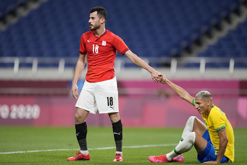  Egypt's Mahmoud El Wench, left, helps Brazil's Richarlison get up during a men's quarterfinal soccer match at the 2020 Summer Olympics, Saturday, July 31, 2021, in Saitama, Japan. (AP Photo/Silvia Izquierdo) 