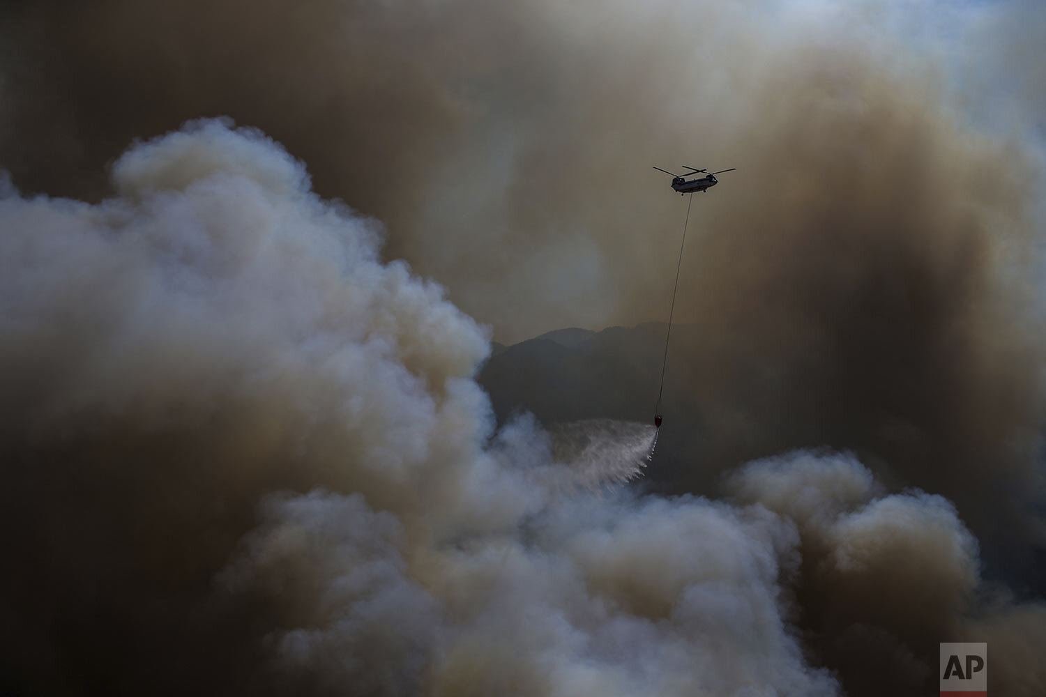  A helicopter participates in a wildfire extinguishing operation, in Koycegiz, Mugla, Turkey, Monday, Aug. 9, 2021. Wildfires in Turkey, described as Turkey's worst in living memory, started on July 28 amid a ferocious heatwave and raged on for days 