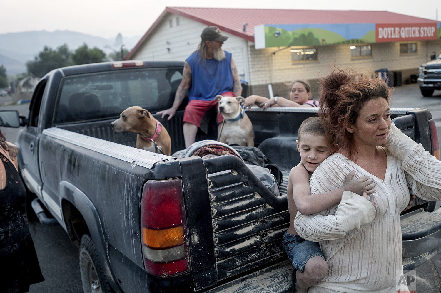  Destiney Barnard holds Raymond William Goetchius while stranded at a gas station near the Dixie Fire on Tuesday, Aug. 17, 2021, in Doyle, Calif. Barnard was helping Goetchius and his family evacuate from Susanville when her car broke down. (AP Photo