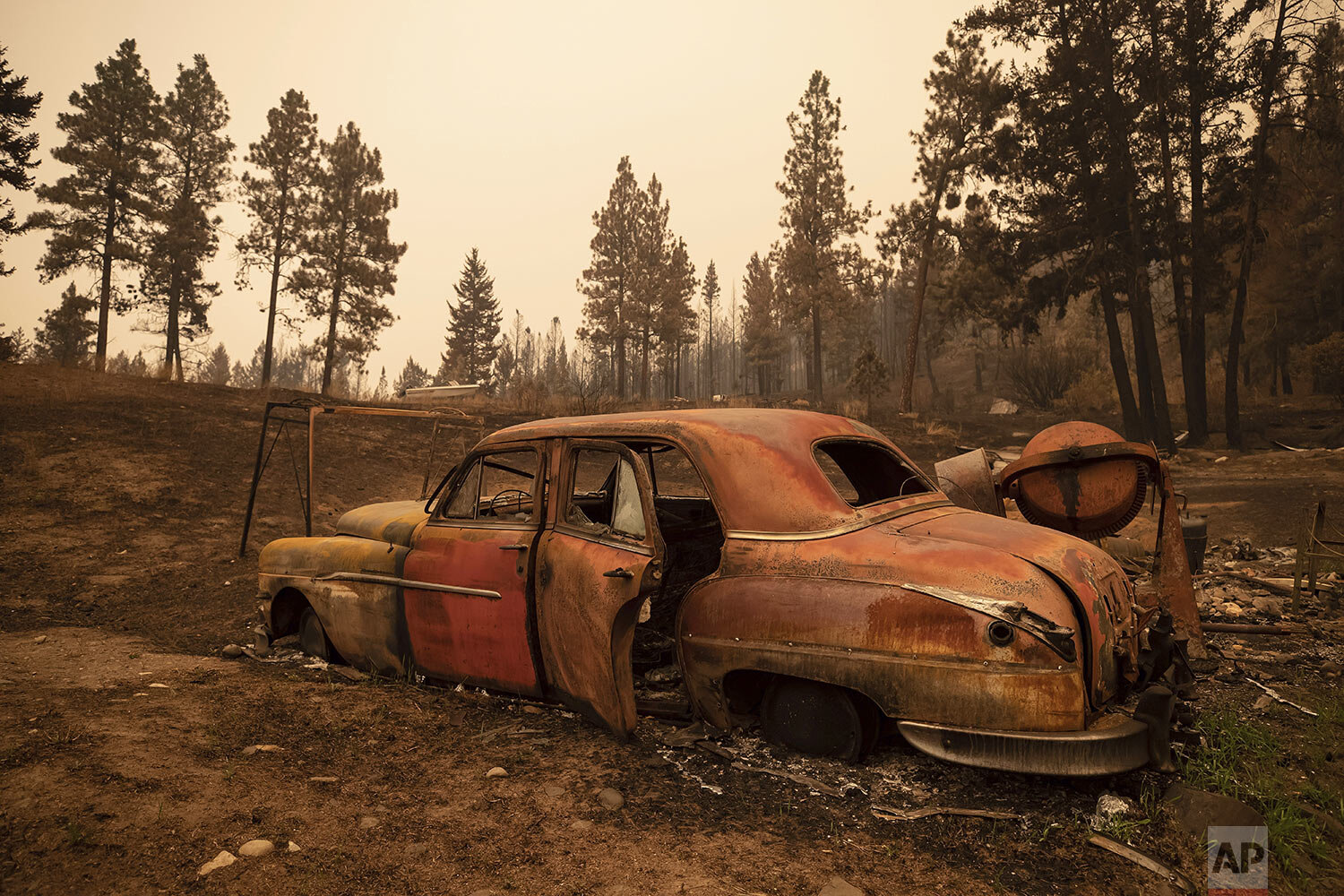  The remains of a classic car is seen on a property destroyed by the White Rock Lake wildfire in Monte Lake, east of Kamloops, British Columbia, Saturday, Aug. 14, 2021. (Darryl Dyck/The Canadian Press via AP) 