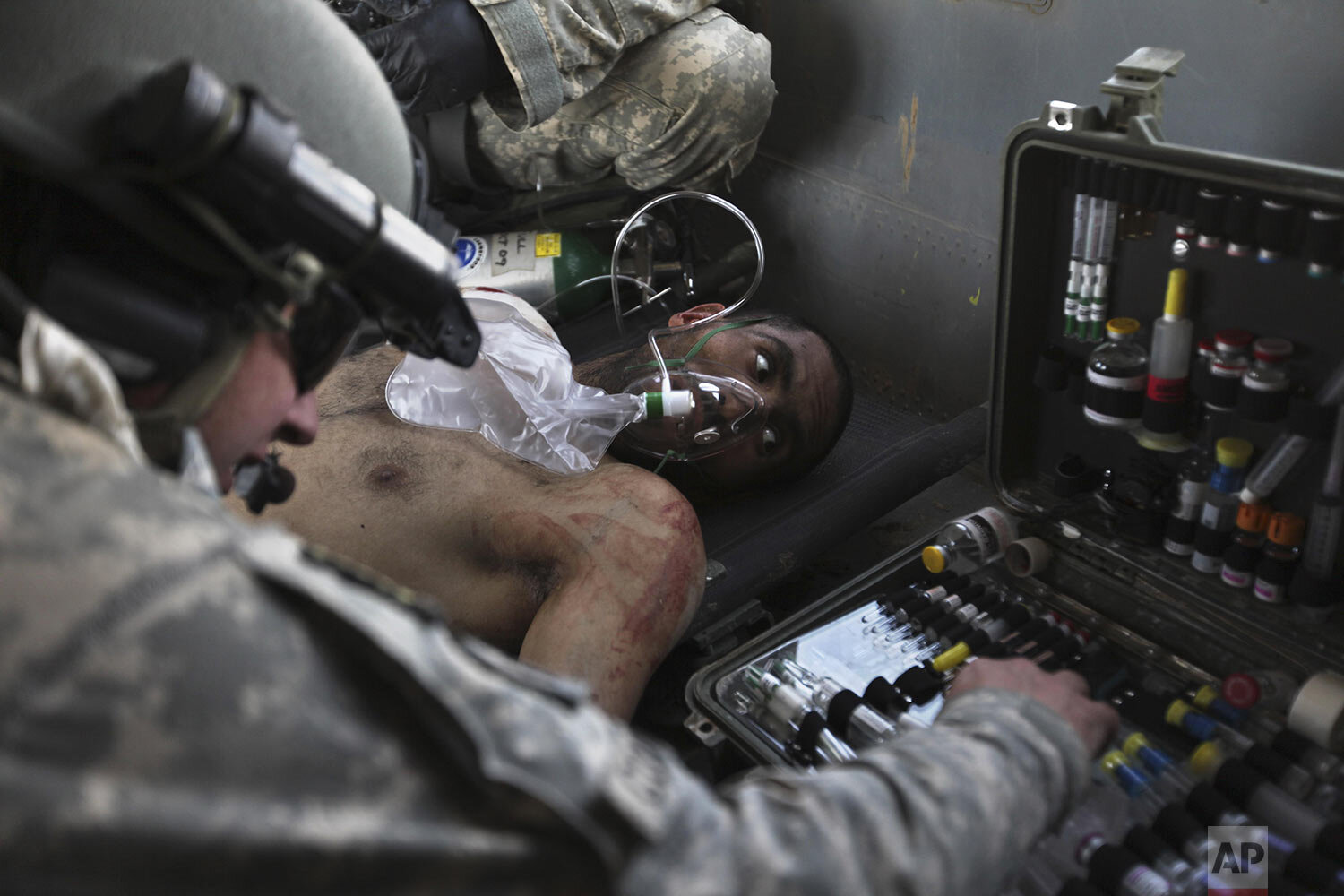  Airborne in a U.S. Army Task Force Pegasus helicopter, U.S. Army Staff Sgt. and flight medic Robert B. Cowdrey, of La Junta, Colo., gives medical care to an Afghan National Army soldier with a gunshot wound, during a medevac mission over Marjah, Hel