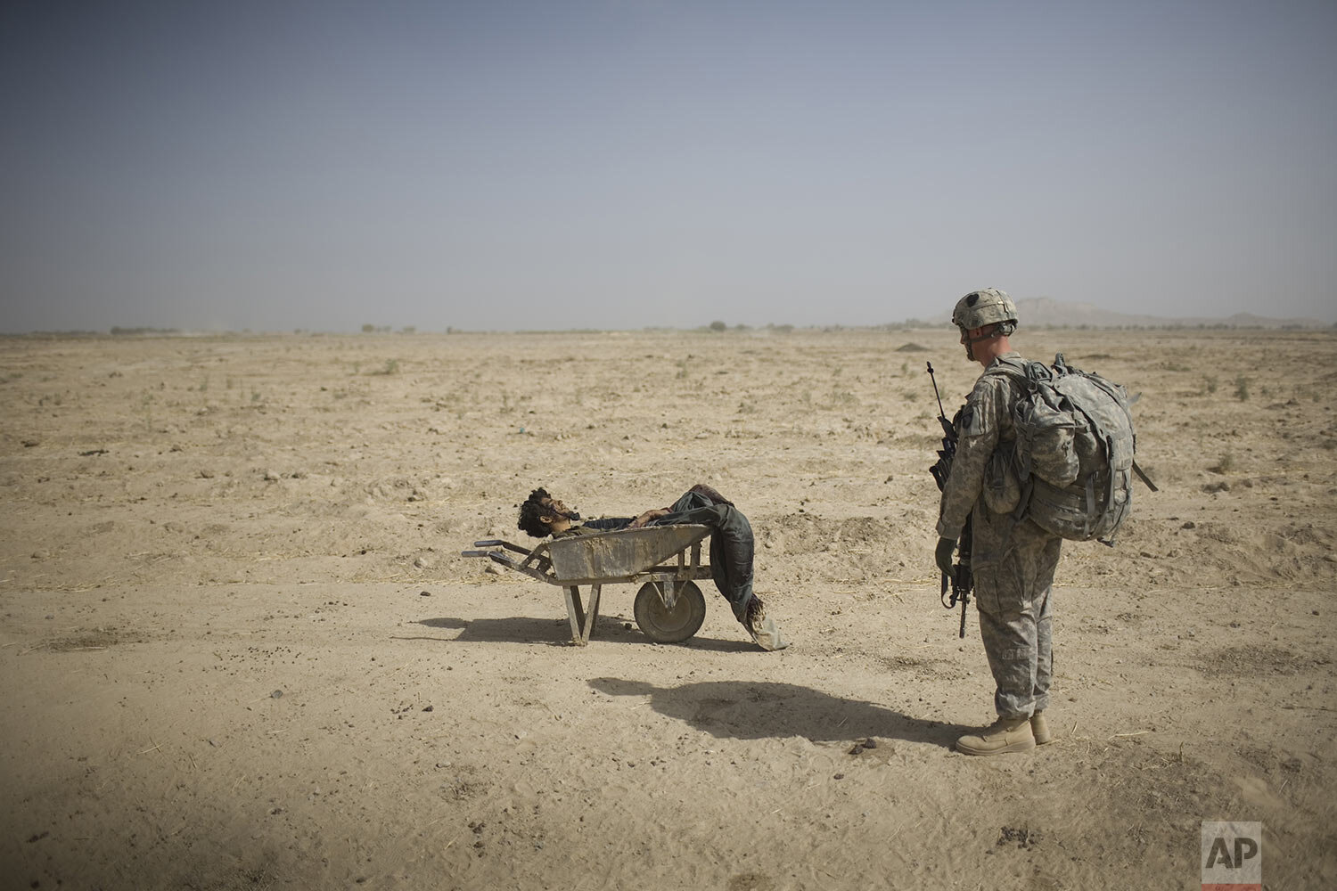  A U.S. Army soldier from Scout Platoon 502 Infantry Regiment, 101st Airborne Division, looks at the body of a suspected Taliban IED emplacer who was killed in a coalition missile strike in Zhari district, Kandahar province, Sunday, Oct. 10, 2010.  T