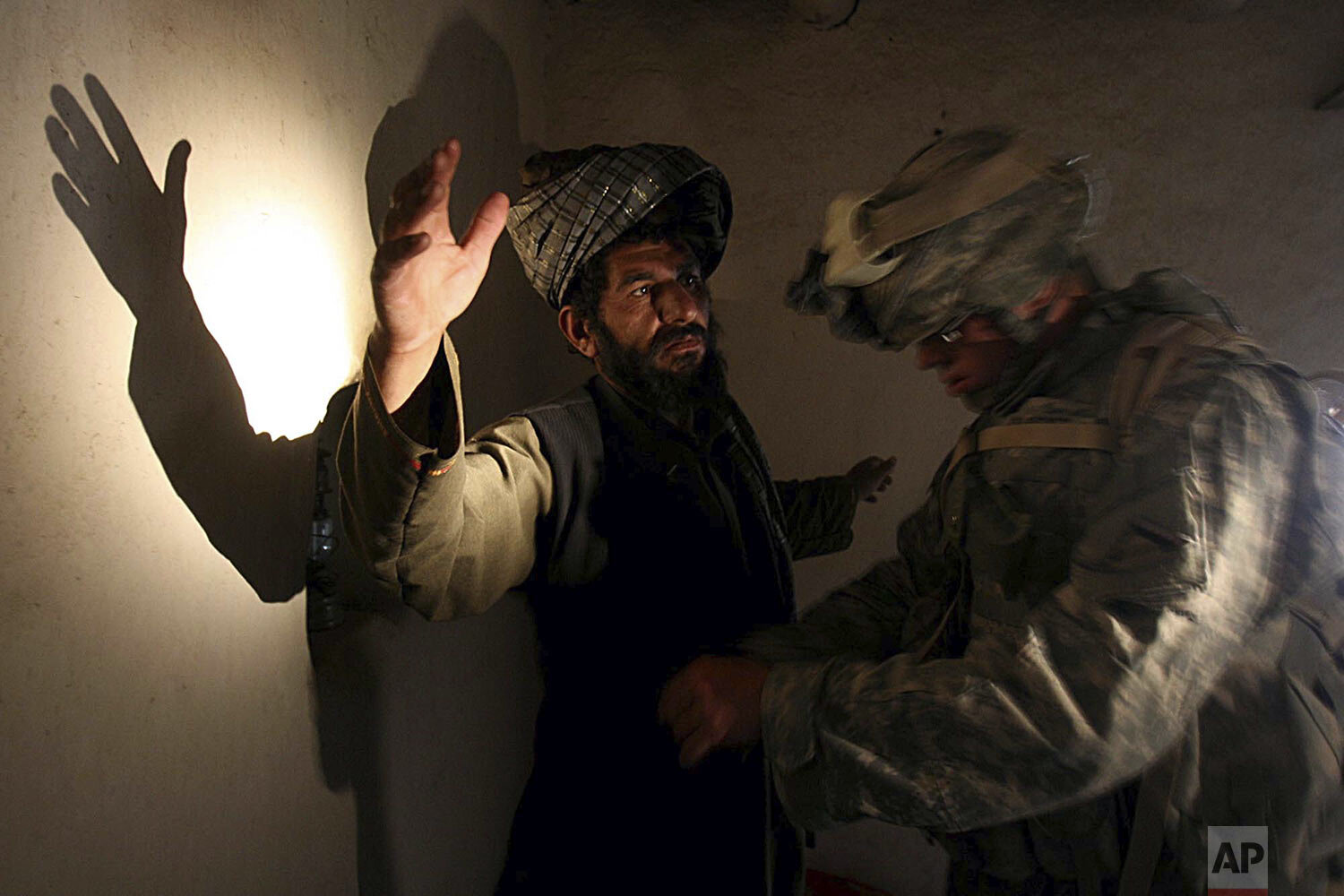  A U.S. soldier of B company, 4th Infantry Regiment frisks an afghan man in his house during a search operation in Sinan village in Zabul province, southeastern Afghanistan, Monday, April. 2, 2007. (AP Photo/Rafiq Maqbool) 