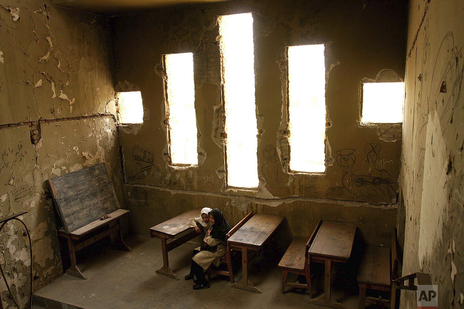  Basera, 13, right, and Saira, 10, wait for their class to begin at Loy Ghar school, in the bombed-out carcass of the Kabul Theater in Afghanistan's capital, April 20, 2005. The bullet-riddled building has become a place of hope for more than 400 stu