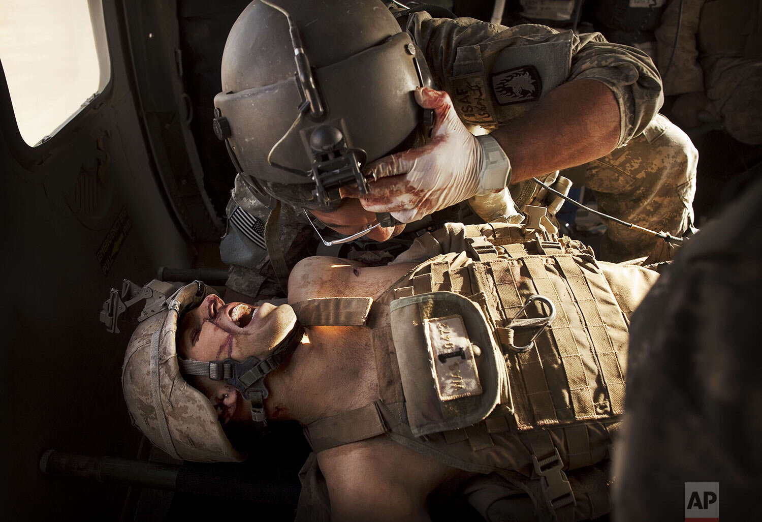  U.S. Army flight medic SGT Jaime Adame, top, cares for seriously wounded Marine CPL Andrew Smith following an insurgent attack on board a medevac helicopter Sunday, May 15, 2011, from the U.S. Army's Task Force Lift "Dust Off", Charlie Company 1-214