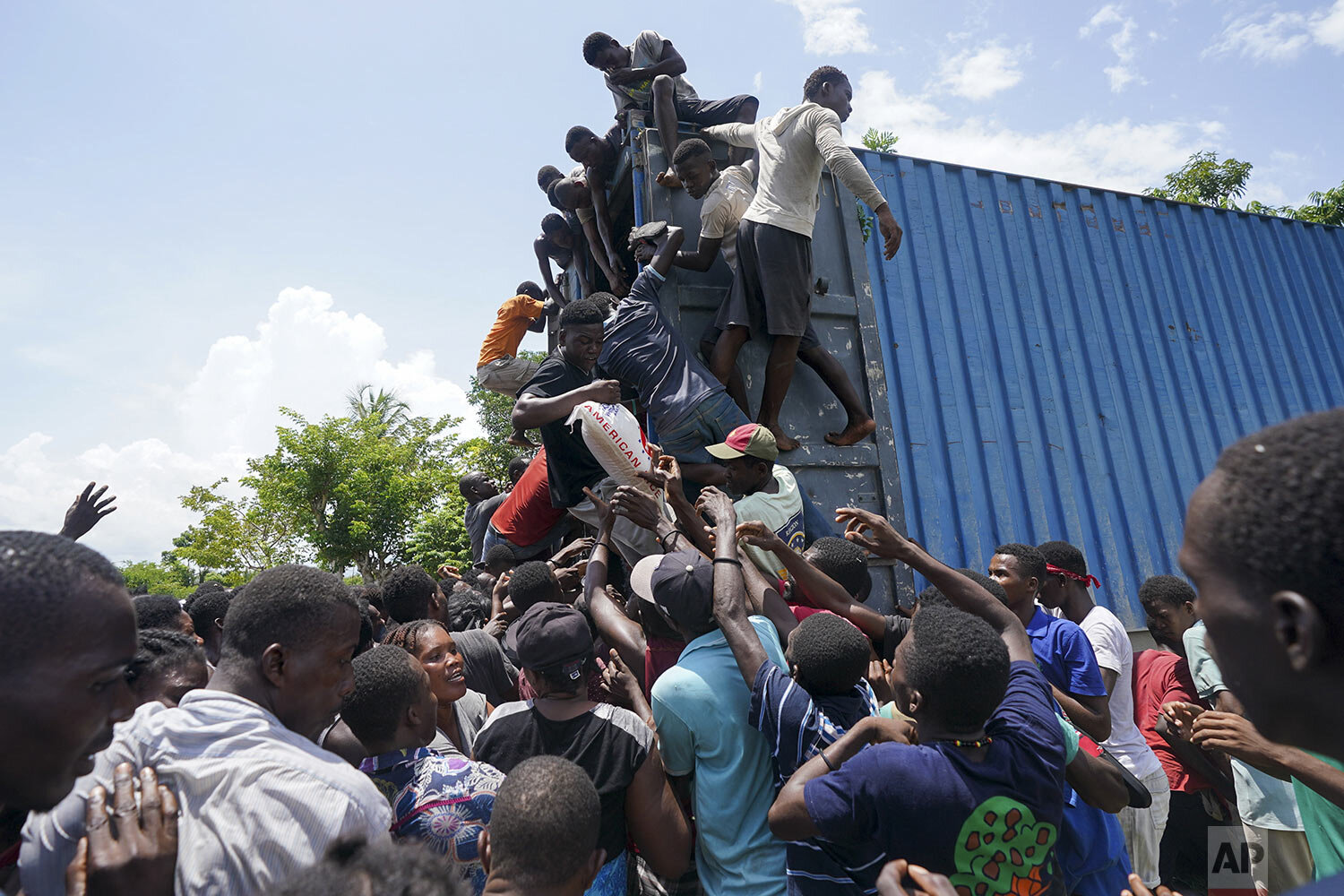  Residents overtake an aid truck in Vye Terre, Haiti, Aug. 20, 2021 as shipments arrive to Haiti a week after the 7.2 magnitude quake. (AP Photo/Fernando Llano, File) 