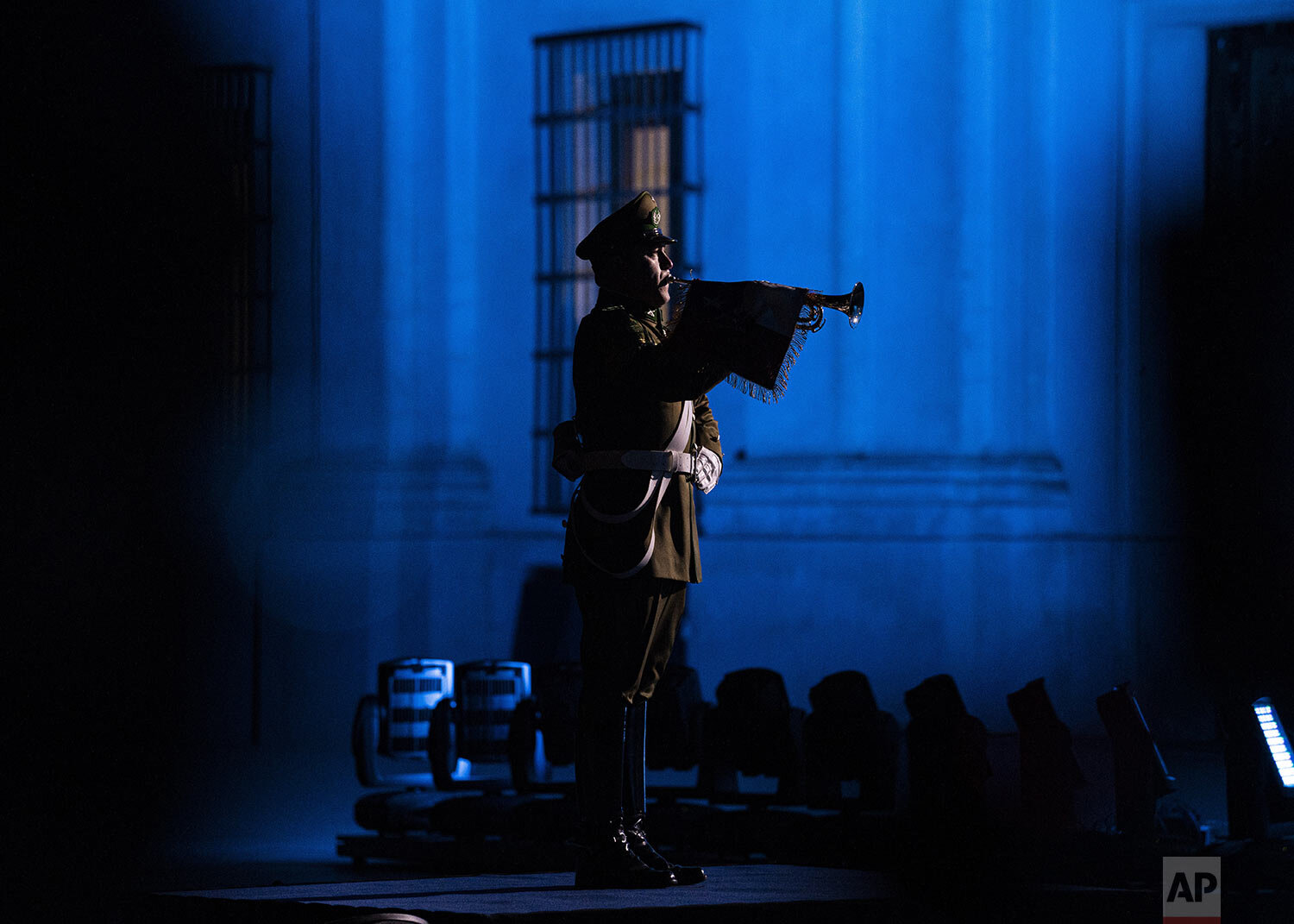  A police officer plays the trumpet during a tribute honoring people who died of COVID-19 at Citizens Plaza outside La Moneda presidential palace in Santiago, Chile, Aug. 8, 2021. (AP Photo/Esteban Felix) 