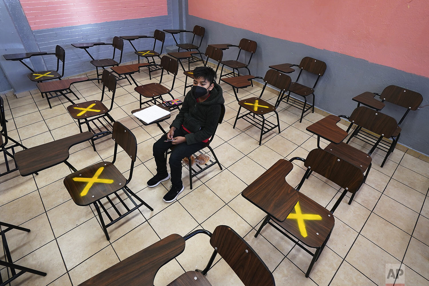  A student sits alone during in-person class at the Republic of Argentina secondary school in Iztacalco, Mexico City, Aug. 30, 2021, on the first day back to school amid the COVID-19 pandemic. (AP Photo/Marco Ugarte) 